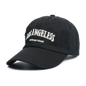 Detailed top view of black cotton baseball cap featuring white 3D letter embroidery