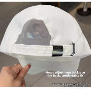Detail of the adjustable metal buckle and white cotton fabric on back of the baseball cap