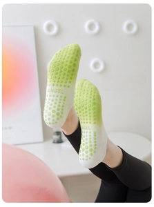 Detail of gradient yoga socks with anti-slip silicone grips and Angel logo on feet