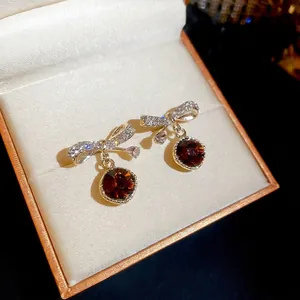 Bowknot earrings with brown round zircon and white pavé crystals in gold jewelry box