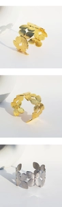 Detailed view of hollow butterfly design on gold and silver open wide cuff bracelets