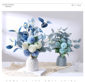 Detail of blue faux hydrangea flowers in a diamond-textured ceramic vase with rope