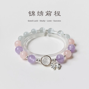 Macro shot of multi-color crystal beads with a silver butterfly charm on clear stand