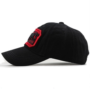 Close-up of black baseball cap with red embroidered square patch and reinforced stitching