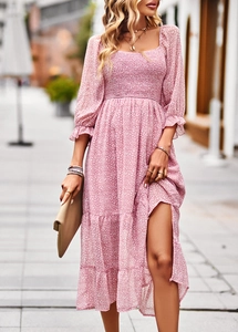 Detail of pink floral dress featuring square neck, pleated waist, and side split hem