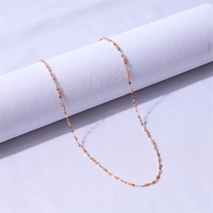 Detail of 18k gold-plated stainless steel chain with orange enamel drop accents