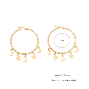 Detail of gold stainless steel hoop earrings featuring dangling stars and moon charms