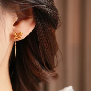 Vintage butterfly drop earrings in gold plating worn by model for an elegant look