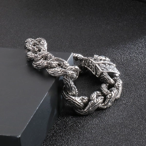 Close-up of gothic stainless steel skull clasp and engraved floral chain links