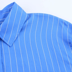 Detail of blue vertical striped shirt showing collar stitching and premium fabric texture