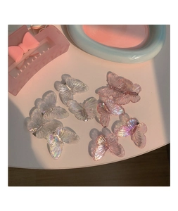 Gros plan de petites pinces à cheveux papillon en tons irisés transparents et roses