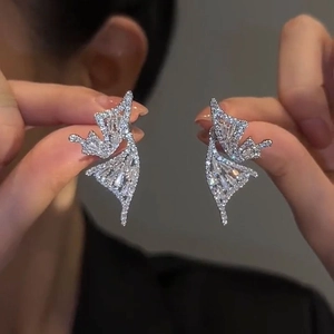 Detail shot of silver butterfly zircon earrings held to show fine craftsmanship and shine