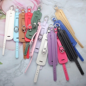 Flat lay of colorful PU leather keychains with metal buckles on marble background