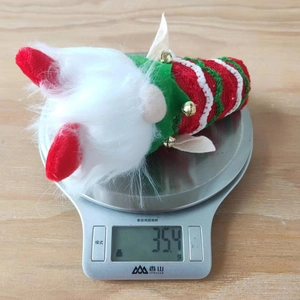 Détail d'un gnome de Noël avec chapeau rayé sur une balance, pesant 35,4 grammes
