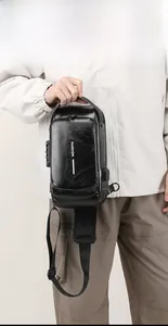 Detail of black crossbody bag featuring a secure side combination lock and USB port