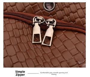 Detail of brown woven texture PU leather and gunmetal zippers on a travel backpack