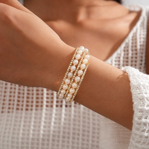 Close-up of elegant multi-layer pearl and rhinestone bracelet on model's wrist