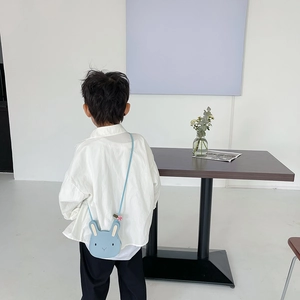 Blue bunny-shaped kids crossbody bag in PU leather shown on a child for size perspective