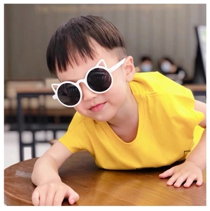 Close-up of white cat-ear sunglasses for kids with dark lenses worn by a cute model