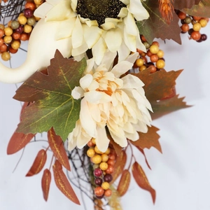 Detail eines Herbstkranzes mit Sonnenblume, weißem Kürbis und bunten Ahornblättern