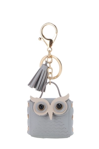 Detail of grey owl coin purse keychain with gold hardware and stylish tassel charm