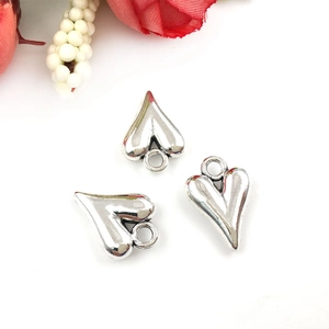 Close-up of three hollow heart-shaped silver alloy pendants for DIY jewelry making