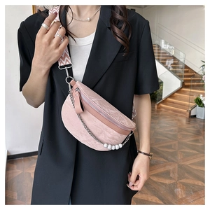 Pink marble textured chest bag with pearl chain and patterned strap worn by model