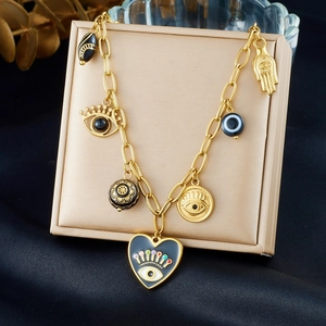 Collier avec pendentif cœur gothique et breloques palmier gravées or noir sur boîte
