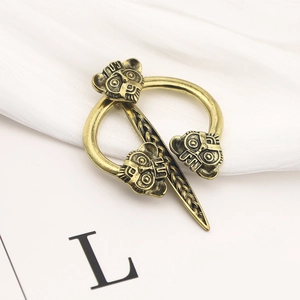 Macro view of vintage bronze Viking brooch featuring carved animal heads in size L