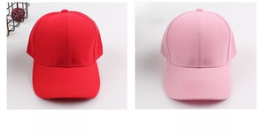 Detail view of cotton baseball caps in vibrant red and soft pink with twill fabric texture