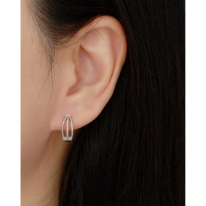 Detail of silver S925 triple-layer twisted hoop earrings with crystals worn by model