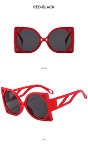 Detail of red cat-eye sunglasses with hollow geometric temples and dark lenses