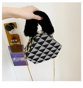 Detail view of triangular bag with black and white geometric pattern and faux fur handle