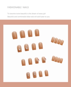 Detail of short square press-on nails with soft pink finish, 3D butterfly and pearl accents