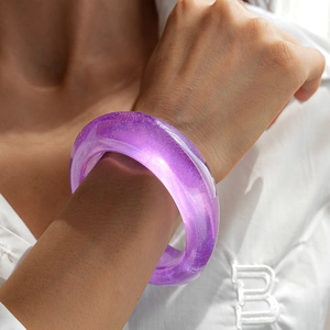 Detail of purple resin bangle with fine glitter texture on model wrist