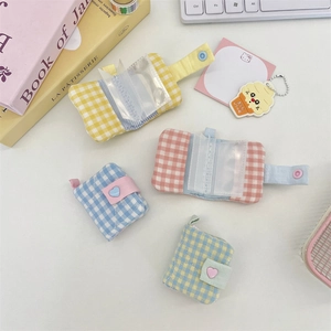 Detailed view of mini checkered fabric photo albums with heart buttons and clear PVC card slots