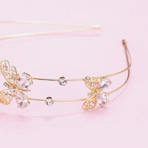 Macro shot of gold butterfly headband with glittering rhinestones on a soft background