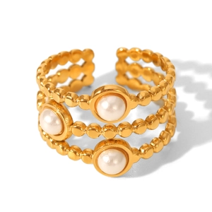 Detail of layered gold beaded ring featuring three elegant white pearls and open design