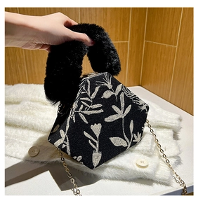Detail of printed hexagonal handbag with black faux fur handle and gold metal chain strap