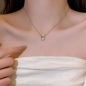 Close-up of a silver butterfly ribbon pendant necklace with sparkling zircons on skin