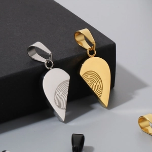 Macro view of gold and silver heart-shaped pendants with unique fingerprint texture