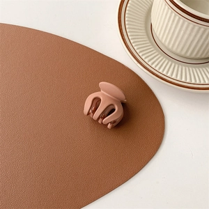 Close-up of matte clay brown mini hair claw clip on a minimalist textured table