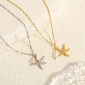 Elegant 18K gold plated starfish necklace with pearl pendant on a white stone background