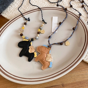 Close-up of leather pony pendants with acrylic stone beads and woven rope detail