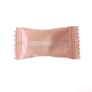 Macro shot of single packed compressed cotton towel in pink rectangular packaging