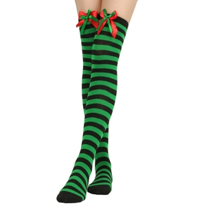 Detail of green and black striped over-knee socks with red satin bow accents