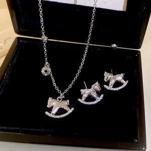 Détail d'un ensemble de bijoux cheval à bascule en argent avec zircons dans un écrin noir