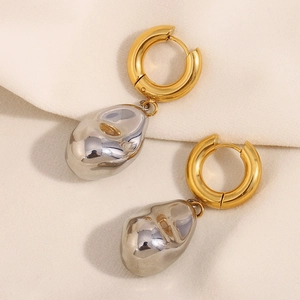 Detailed shot of two-tone oval drop earrings with gold hoop and silver fluid pendant