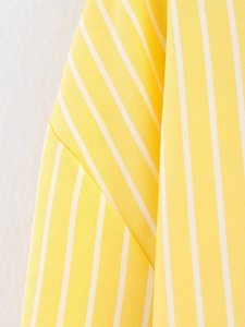 Close-up detail of yellow and white striped fabric texture and stitching on the shirt
