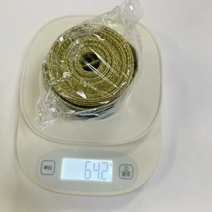 Detailed view of festive gold glitter ribbon roll weighed on a scale for 64.2g